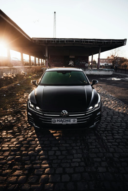 the car is parked on a brick parking lot near a large building