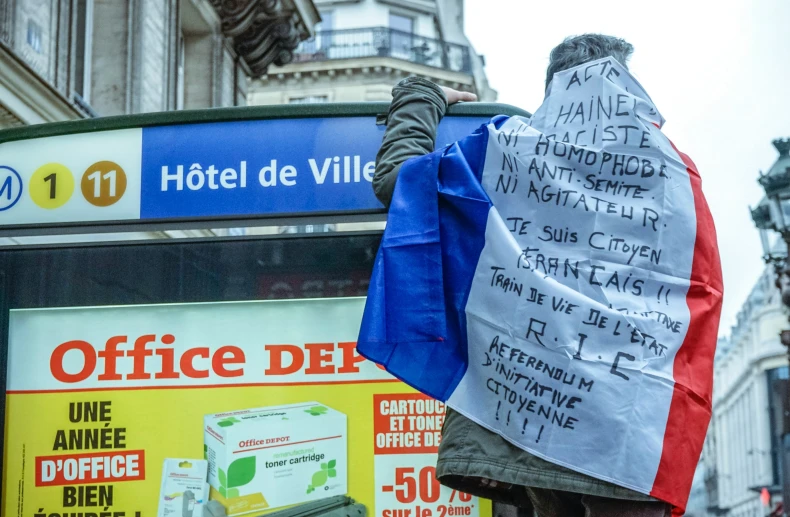 a guy with some signs standing near a bus