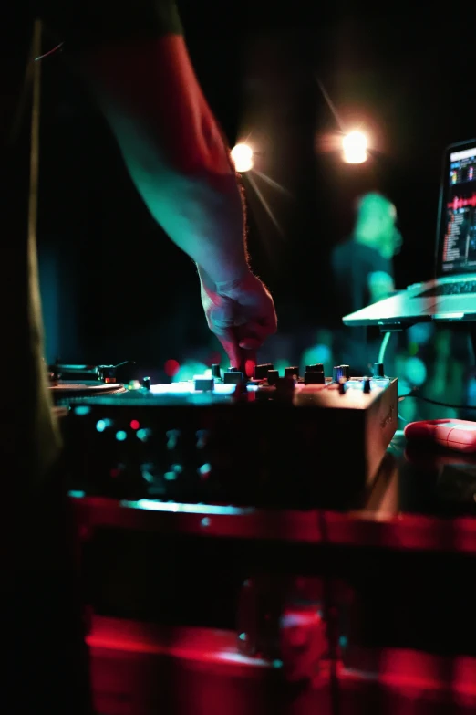 a dj mixing at an event with a laptop