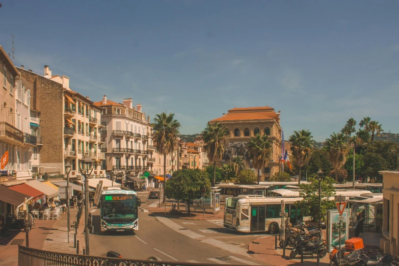 buses and motorcycles drive down a city street