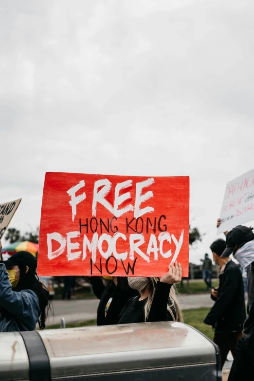 some people are holding a sign and standing outside