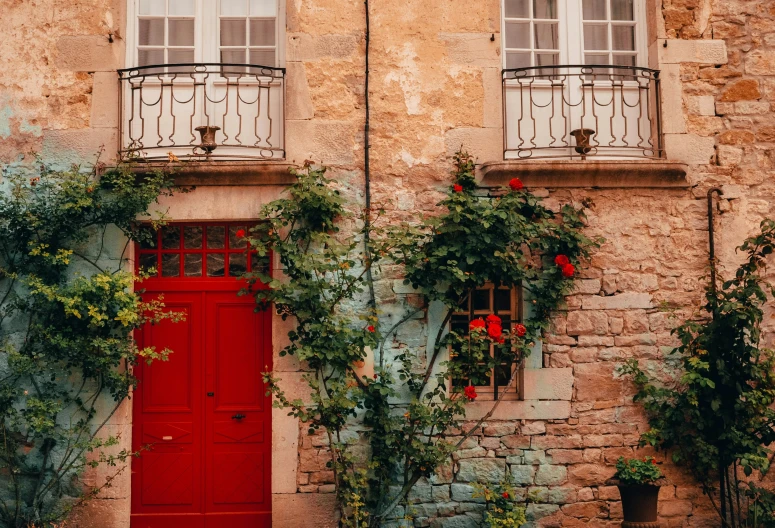 a red door with two windows is between two houses