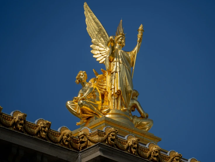 gold statue in the center of the city with other decorations on top