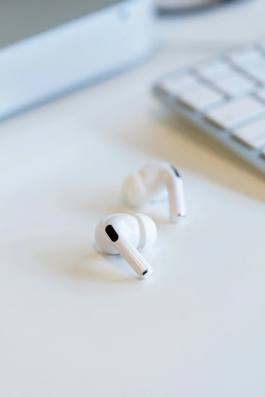 ear buds sitting on a table next to a keyboard