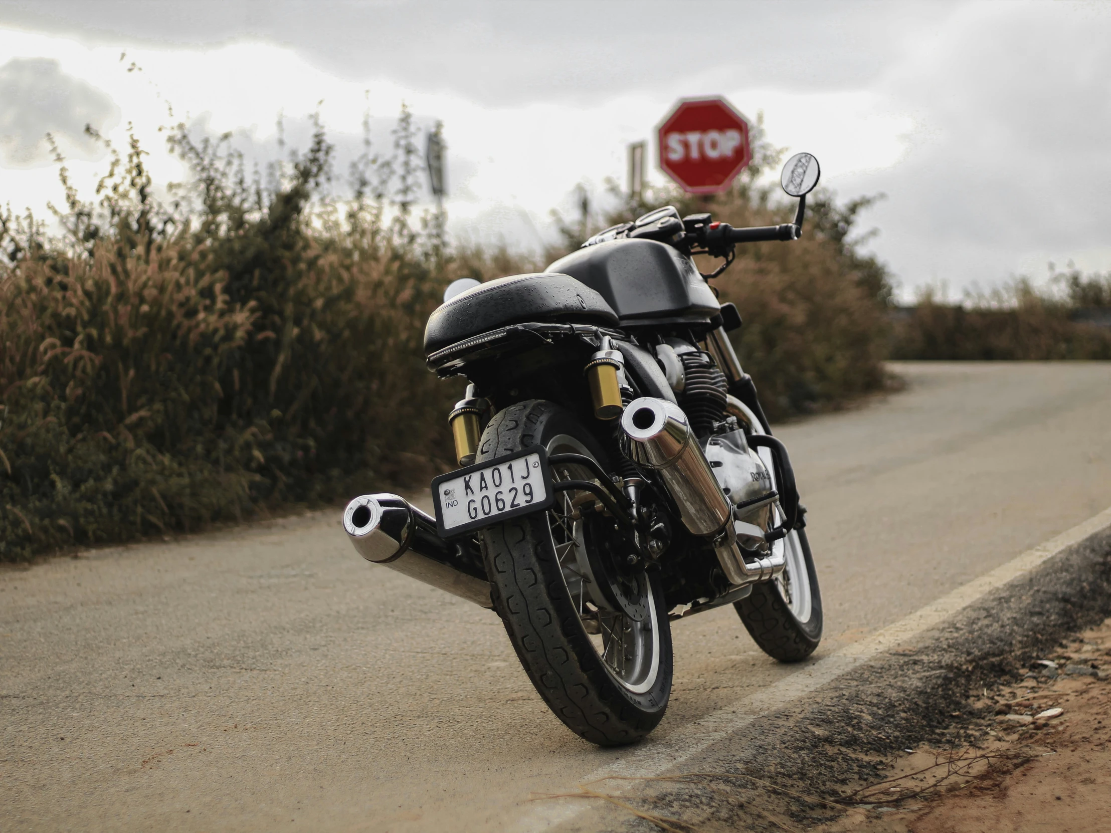 a black motorcycle that is next to a stop sign