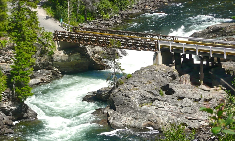 a bridge is over looking a river and rocks