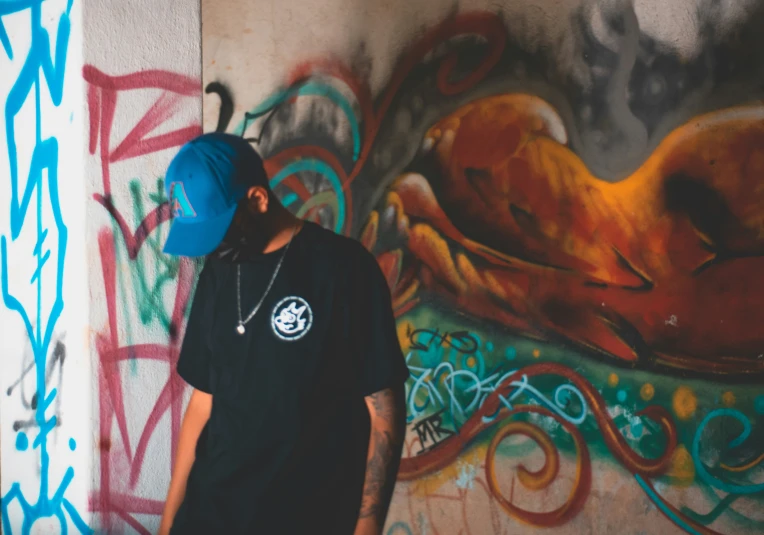 a man stands in front of a mural