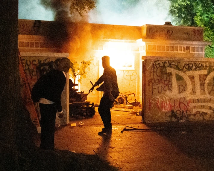 two men are standing outside as the firemen look on