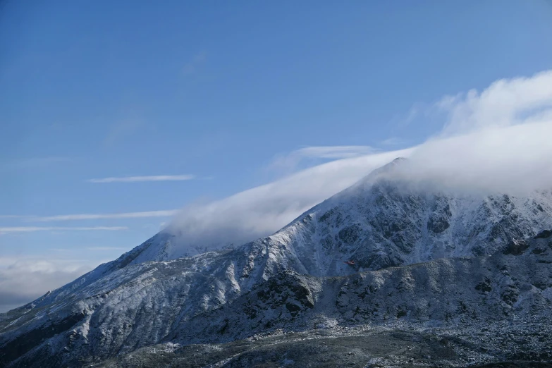 snow covered mountains covered in thick clouds