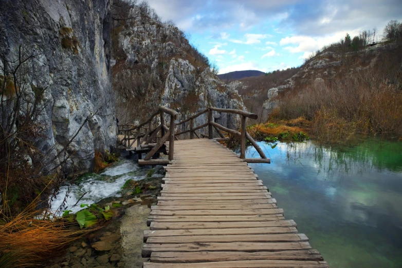 there is a wooden bridge crossing the water