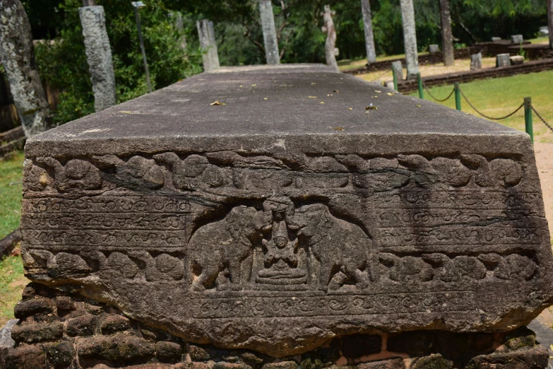 a large rock with designs in it sitting on a platform