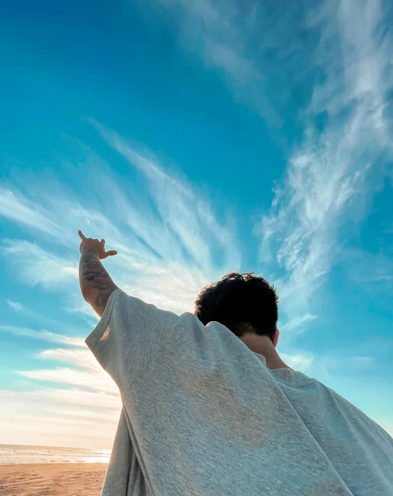 a man in a towel is flying a kite on the beach