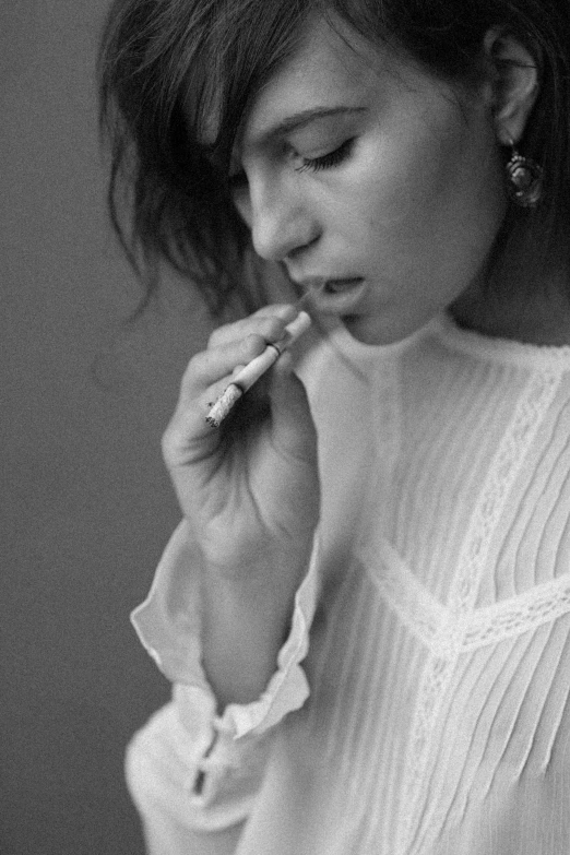 a young woman holds a toothbrush to her mouth