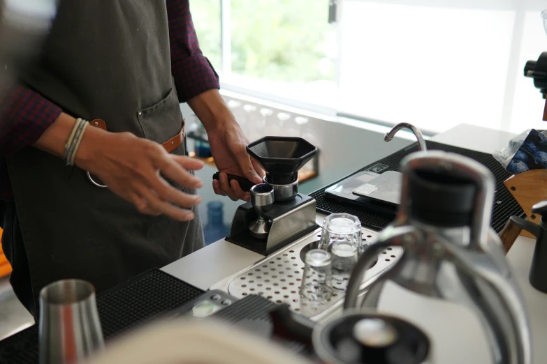 people pouring water into a coffee pot