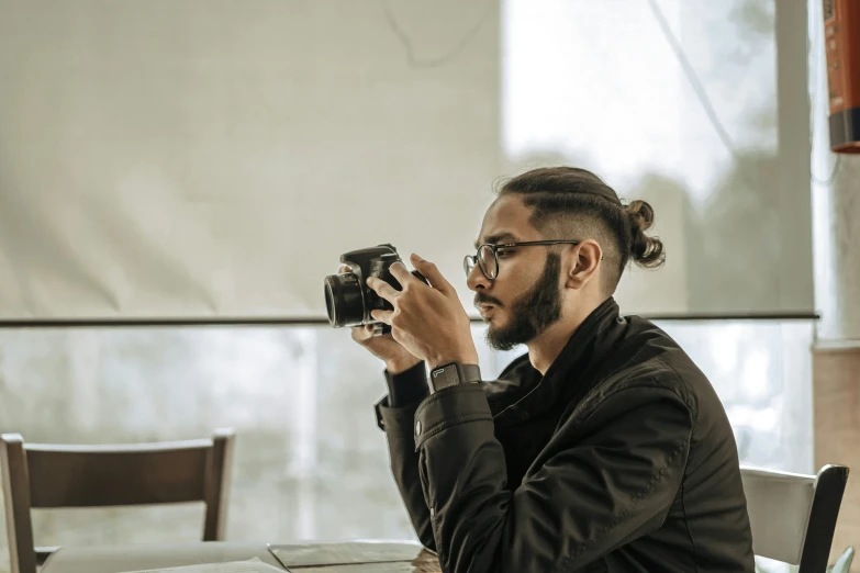 a man sitting at a table and taking a picture