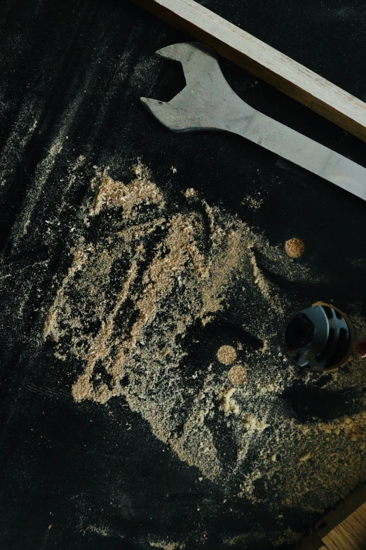 a wooden object on the ground with tools laying nearby