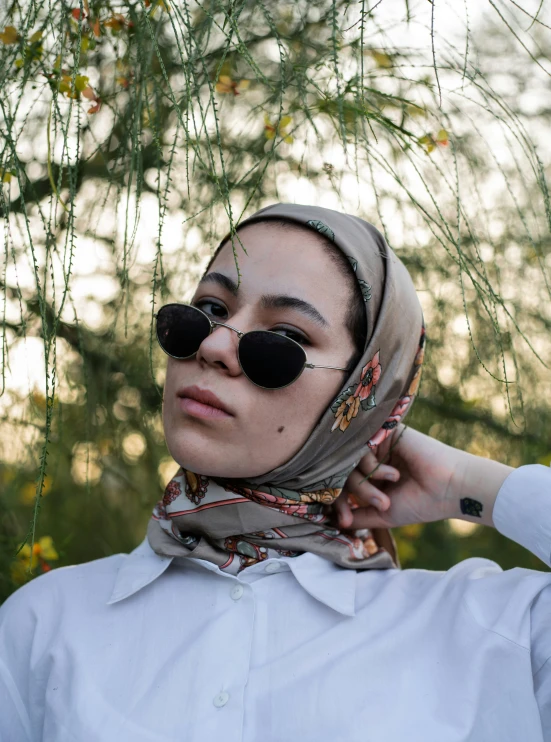 woman with sun glasses in front of a tree