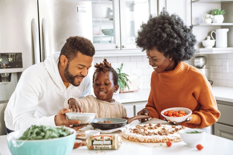 a man and two little girls and a man making food