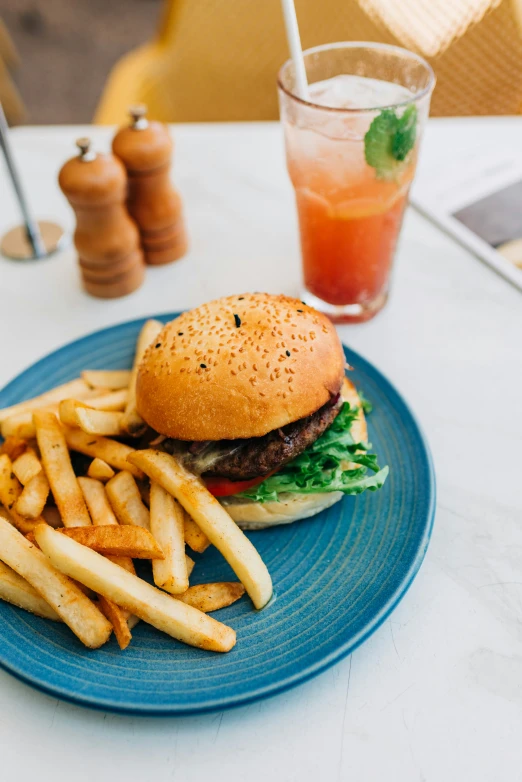 a burger, fries and beverage on a table