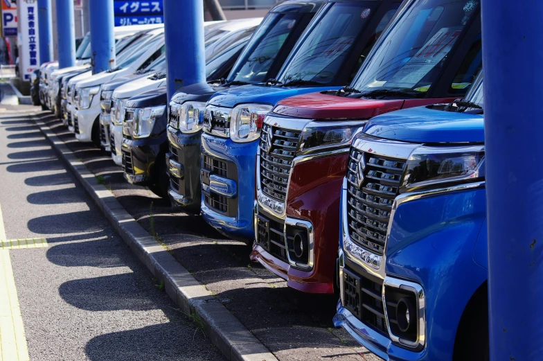 the row of vehicles are painted in different colors