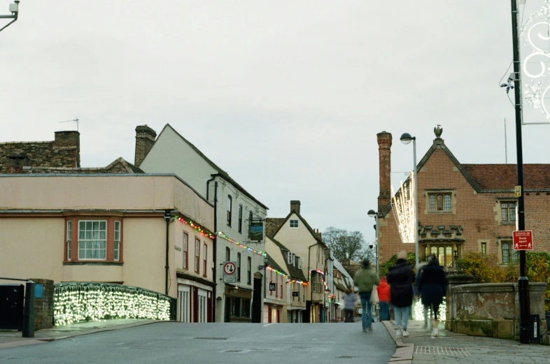 people walking on a road with shops and buildings