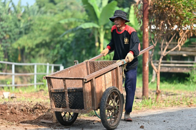 an elderly woman hing a wagon down the road