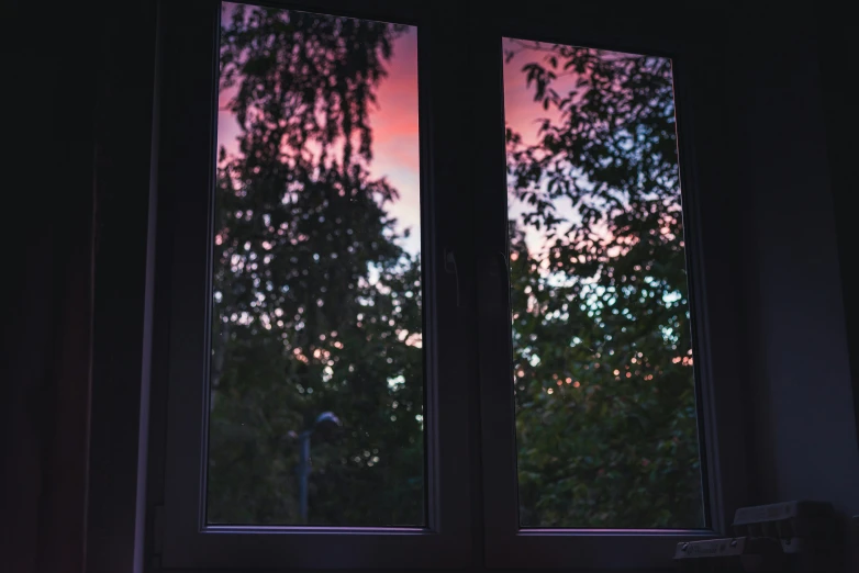 a window in the dark with trees outside it