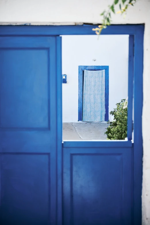 a blue doorway is opened in a white wall