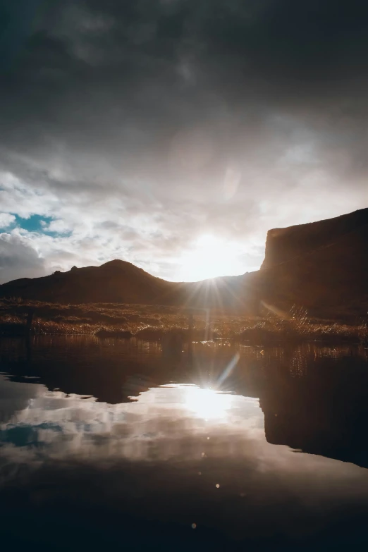 the sun shines through clouds over a river