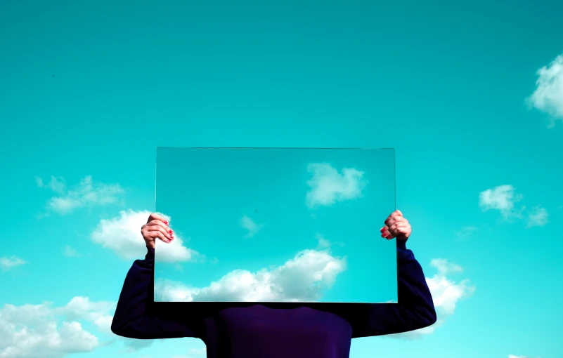 a person in black shirt holding up a blank board