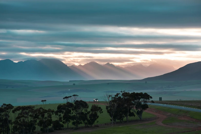 mountains and trees, with a few trees and lights shining brightly in the distance