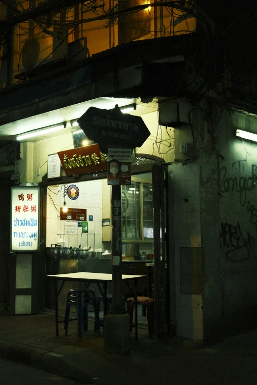 a dark street at night with signs and tables