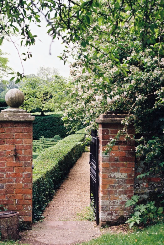 two archways that lead into a garden with hedges