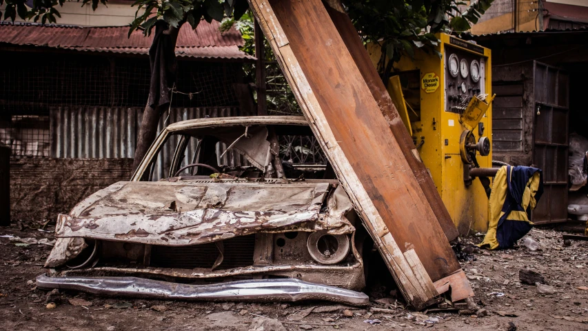 an old car sits abandoned in the dirt