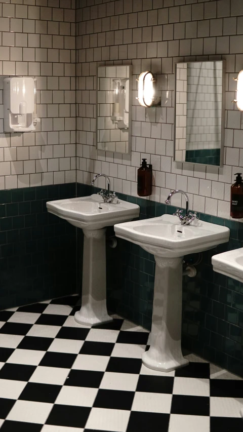 three sinks are in a bathroom with checkered floors