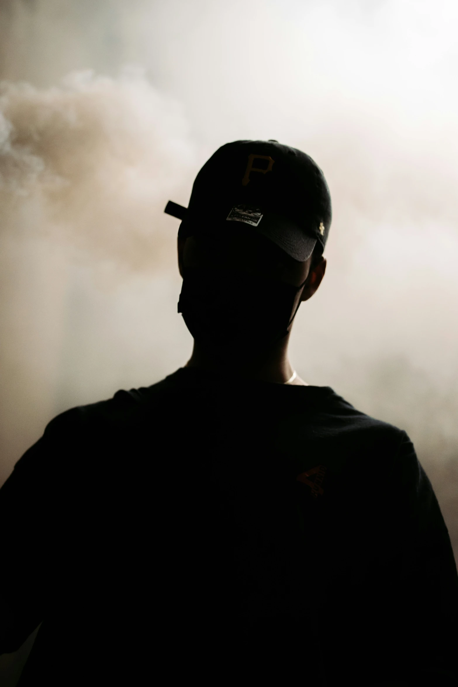 a man in baseball cap and a black background