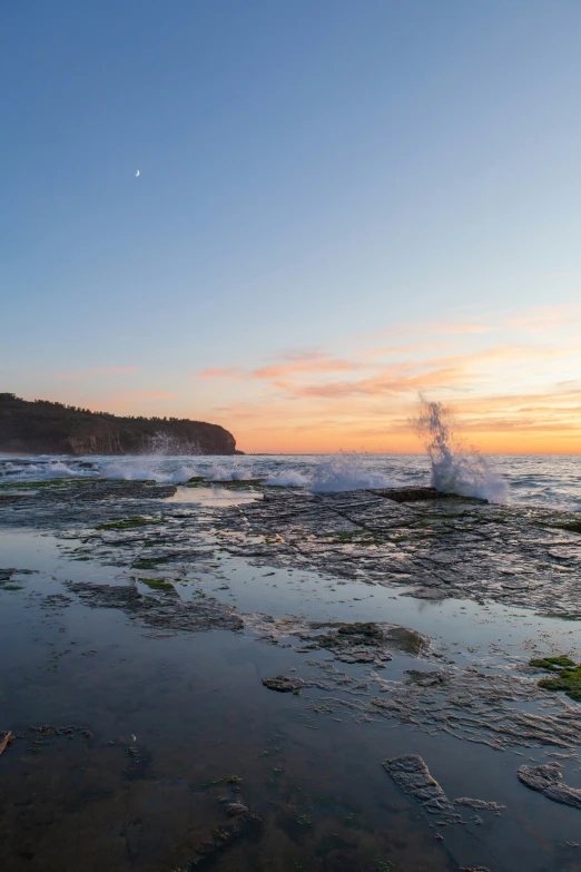 some ice on the beach next to a cliff