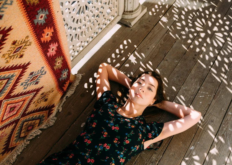 a woman is laying on the ground next to a carpet