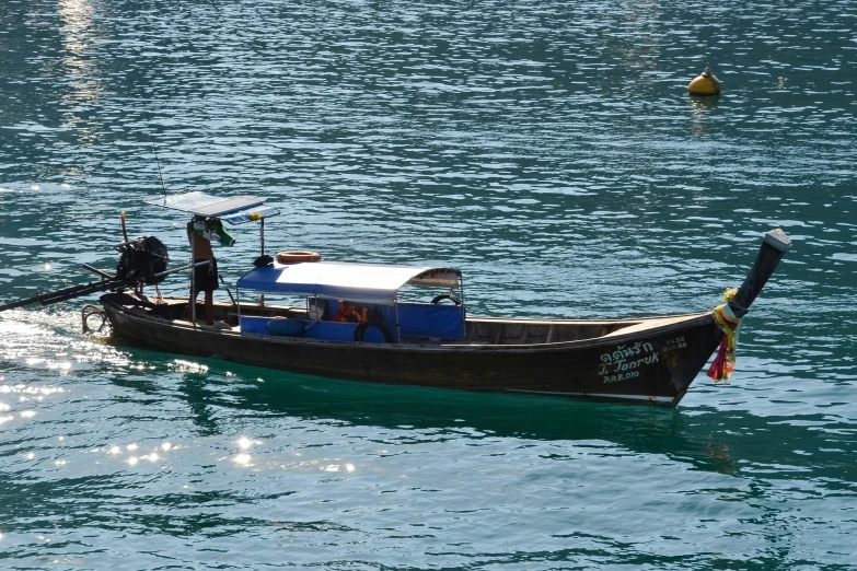 a small boat sits on the water as people fly kites