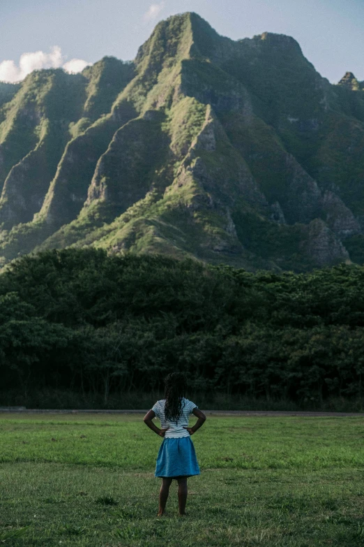 the  in the blue dress is watching the mountains