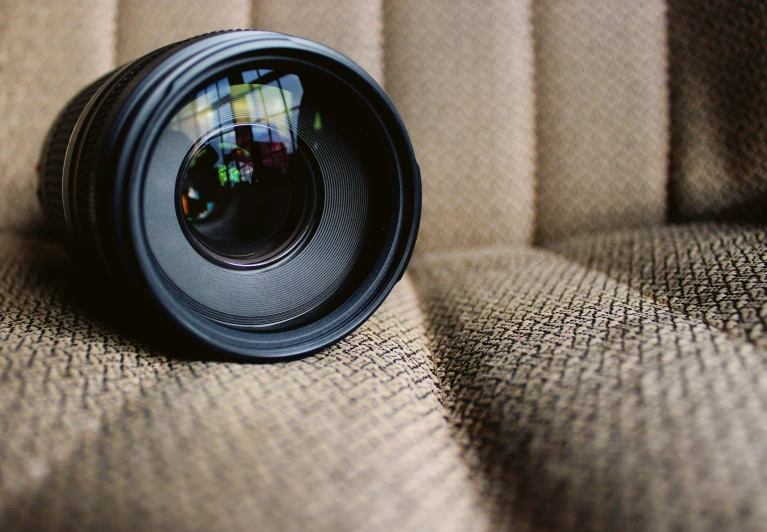 a camera lens on the fabric with its reflection