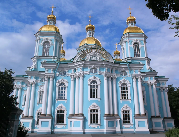 the sky blue building has gold domed roofs