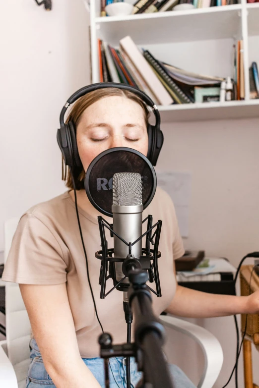 the woman is recording the song in the microphone