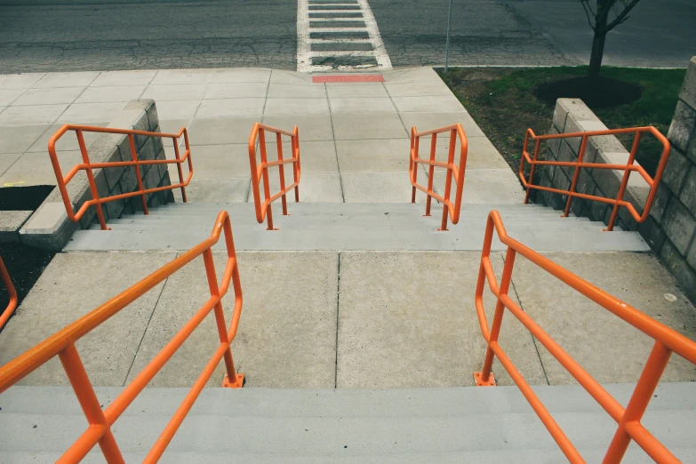 orange bars on a sidewalk near a street