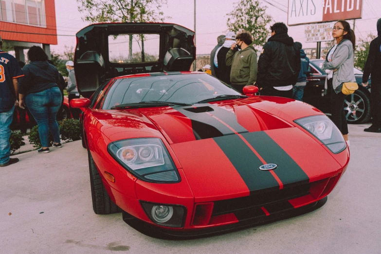 a red and black car parked next to a building