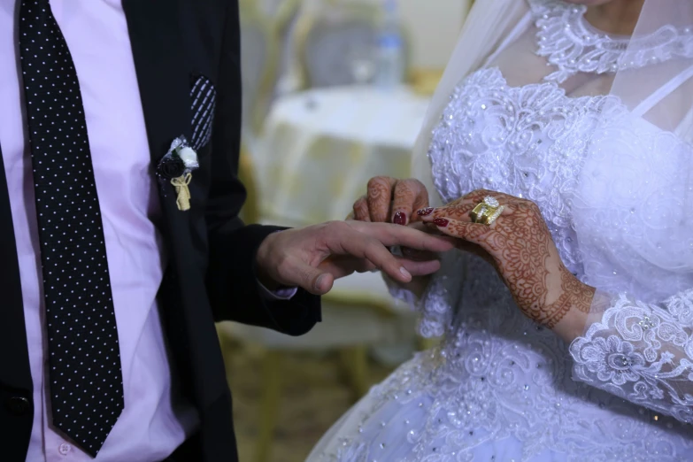 bride and groom exchanging rings with hands holding each other
