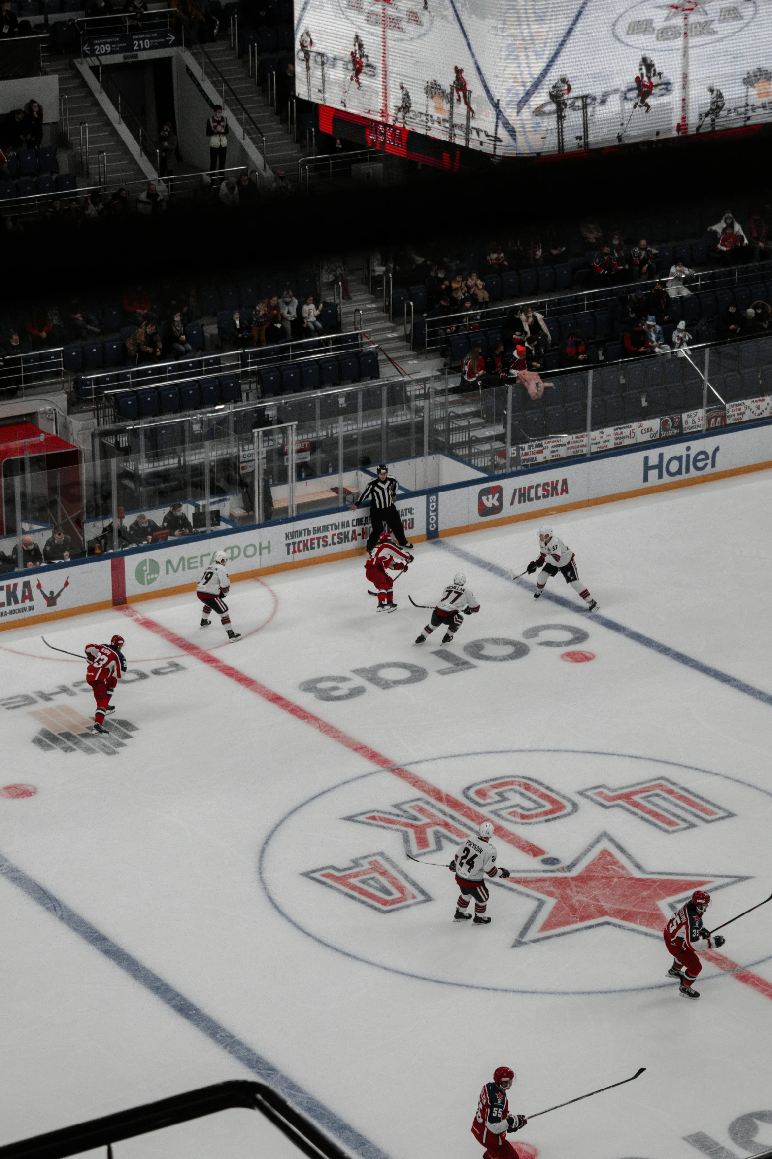 two teams playing in an arena with players in the stands