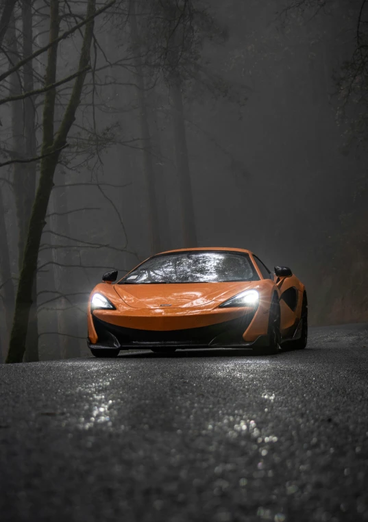 a very pretty orange car in the road