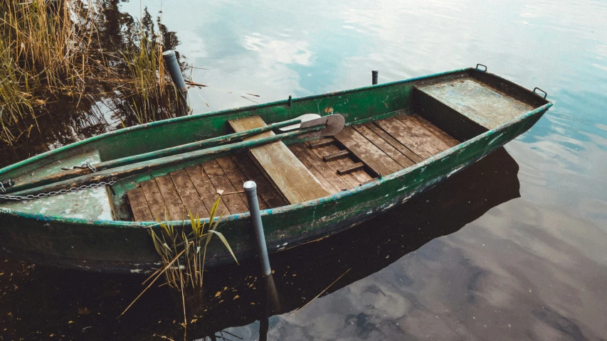 the green boat has an oars on it