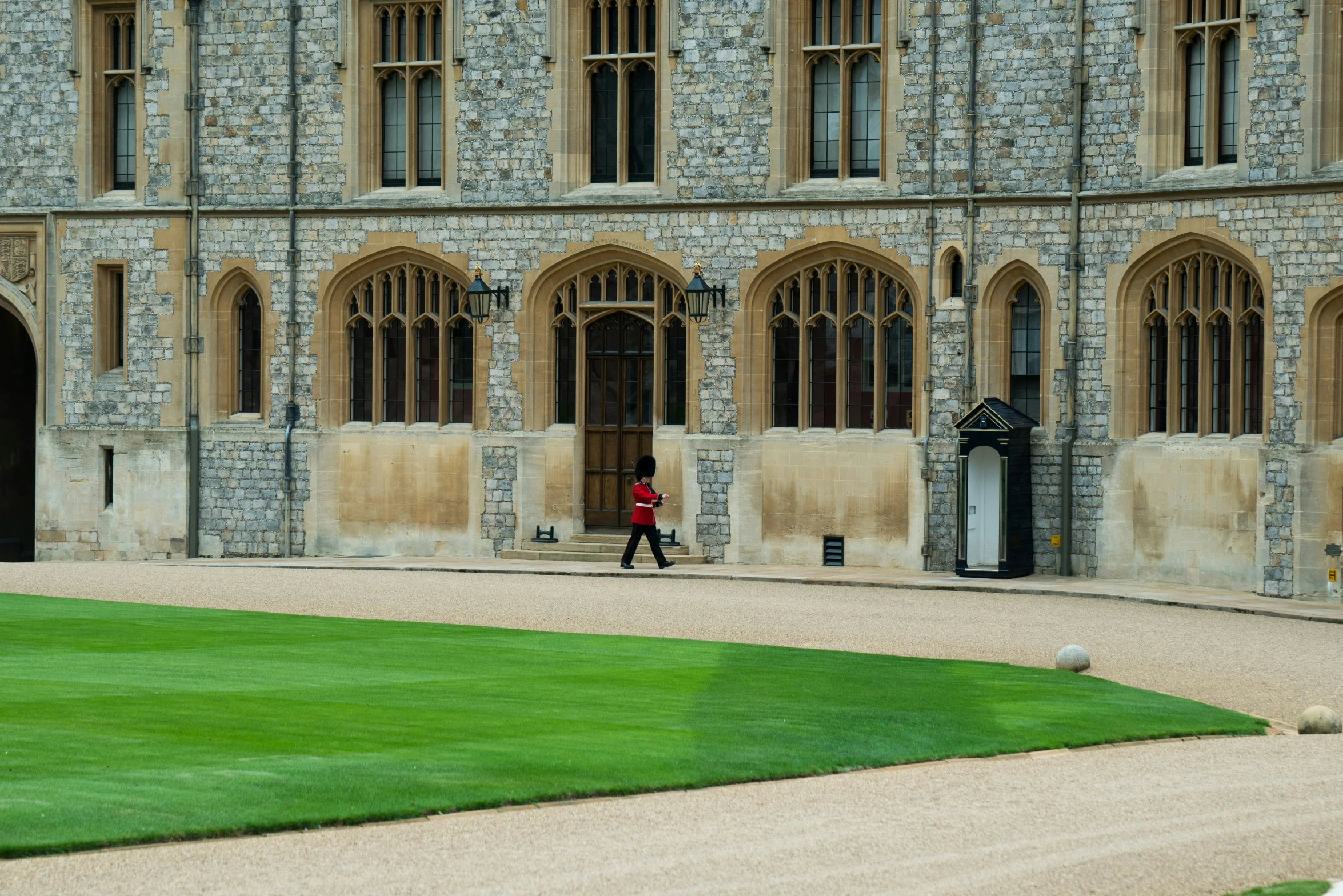 a man in a red jacket walking past the main building